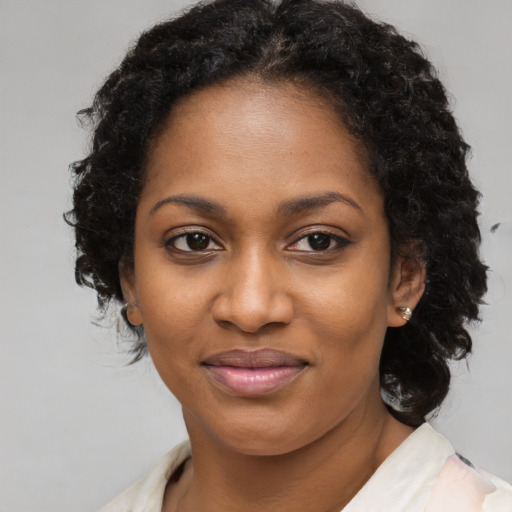 Joyful black young-adult female with long  brown hair and brown eyes