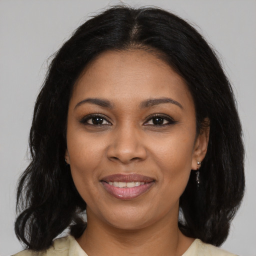 Joyful black young-adult female with medium  brown hair and brown eyes