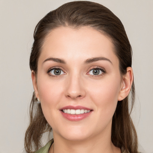 Joyful white young-adult female with long  brown hair and green eyes