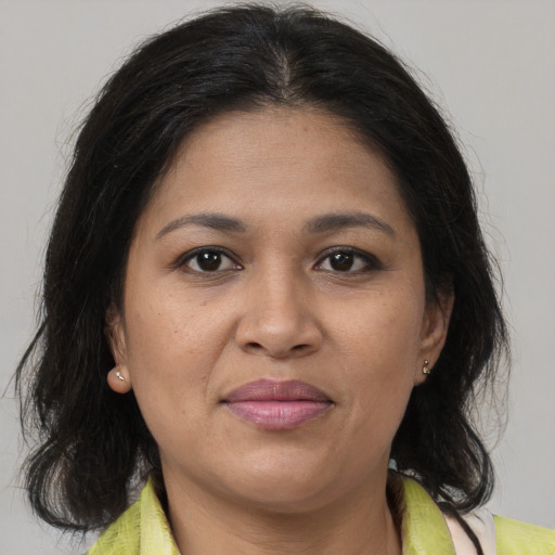 Joyful latino adult female with medium  brown hair and brown eyes