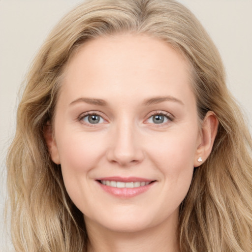 Joyful white young-adult female with long  brown hair and blue eyes