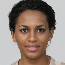 Joyful black young-adult female with short  brown hair and brown eyes