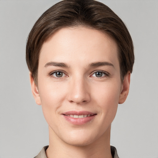 Joyful white young-adult female with short  brown hair and grey eyes