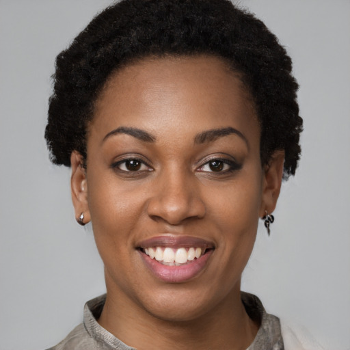 Joyful black young-adult female with short  brown hair and brown eyes