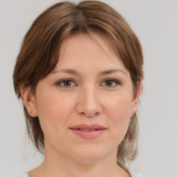 Joyful white young-adult female with medium  brown hair and grey eyes