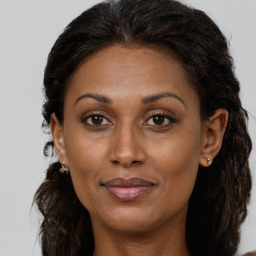 Joyful black adult female with medium  brown hair and brown eyes