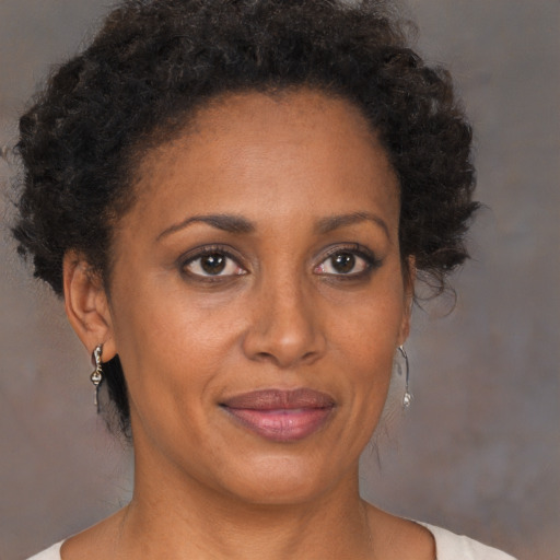 Joyful black adult female with short  brown hair and brown eyes