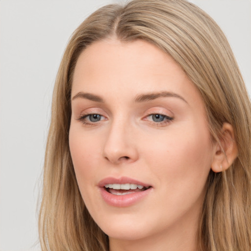 Joyful white young-adult female with long  brown hair and blue eyes