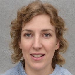 Joyful white adult female with medium  brown hair and blue eyes