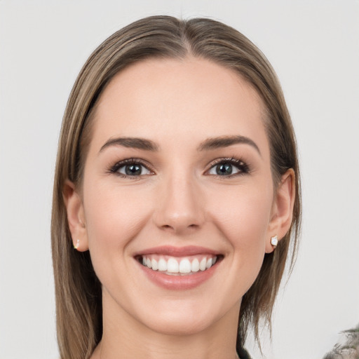 Joyful white young-adult female with medium  brown hair and grey eyes