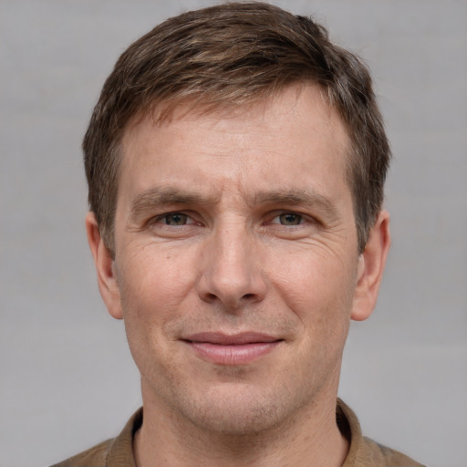 Joyful white adult male with short  brown hair and grey eyes