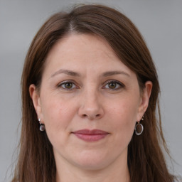 Joyful white adult female with long  brown hair and grey eyes