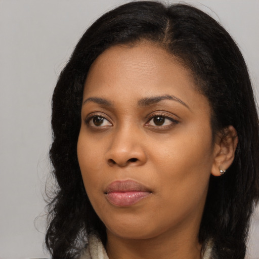 Joyful black young-adult female with long  black hair and brown eyes