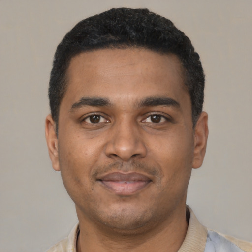 Joyful black young-adult male with short  black hair and brown eyes