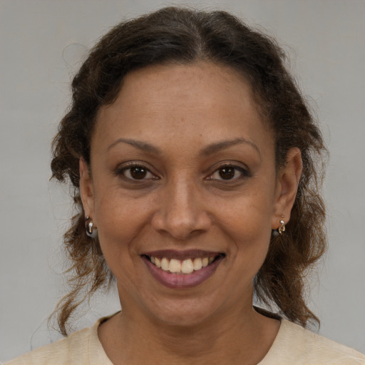 Joyful latino adult female with medium  brown hair and brown eyes