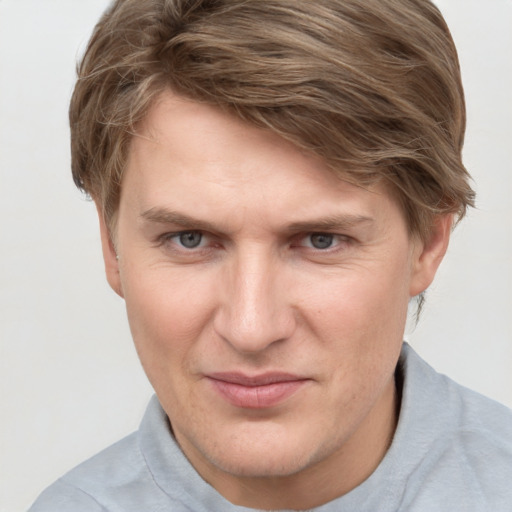 Joyful white young-adult male with short  brown hair and blue eyes