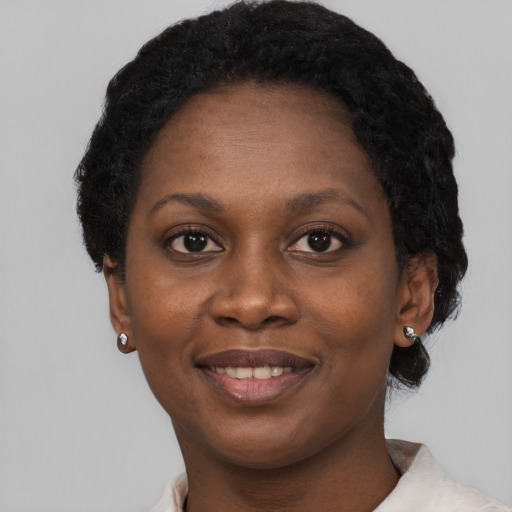 Joyful black young-adult female with short  black hair and brown eyes