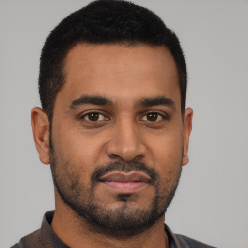 Joyful black young-adult male with short  black hair and brown eyes