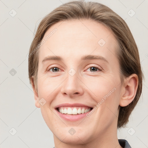 Joyful white young-adult female with medium  brown hair and grey eyes