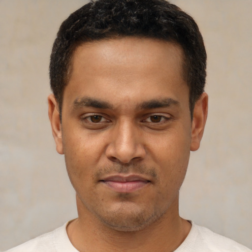 Joyful latino young-adult male with short  brown hair and brown eyes