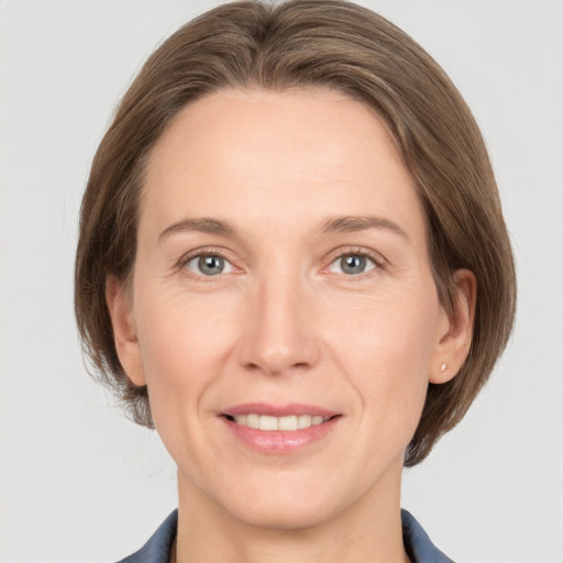 Joyful white adult female with medium  brown hair and grey eyes