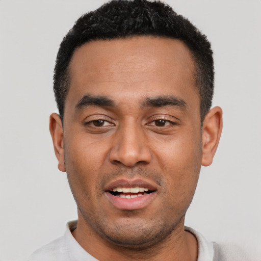 Joyful latino young-adult male with short  black hair and brown eyes