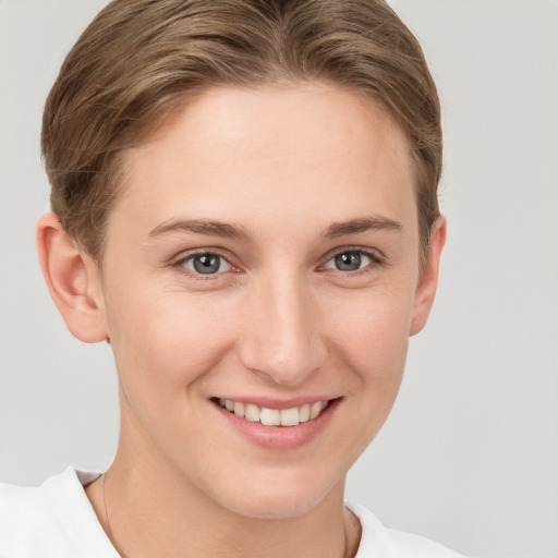 Joyful white young-adult female with short  brown hair and grey eyes