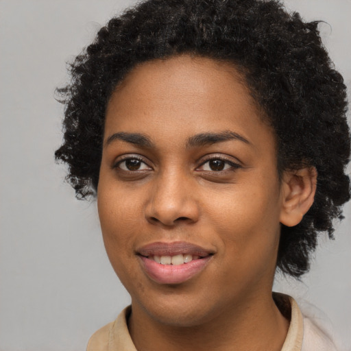 Joyful black young-adult female with short  black hair and brown eyes