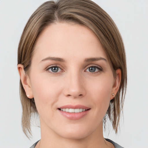 Joyful white young-adult female with medium  brown hair and grey eyes