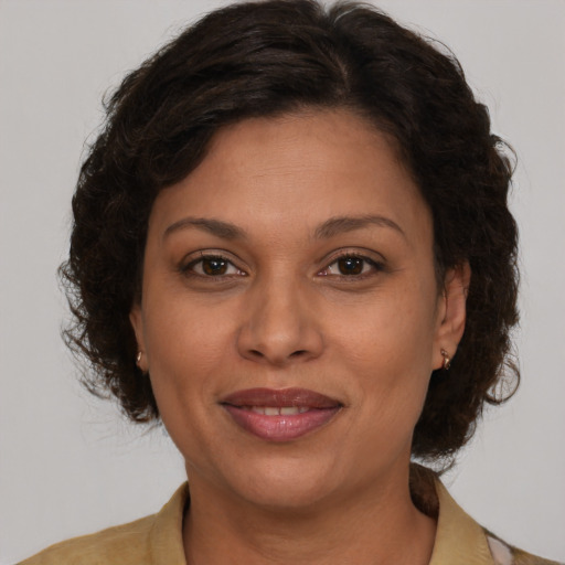 Joyful latino adult female with medium  brown hair and brown eyes