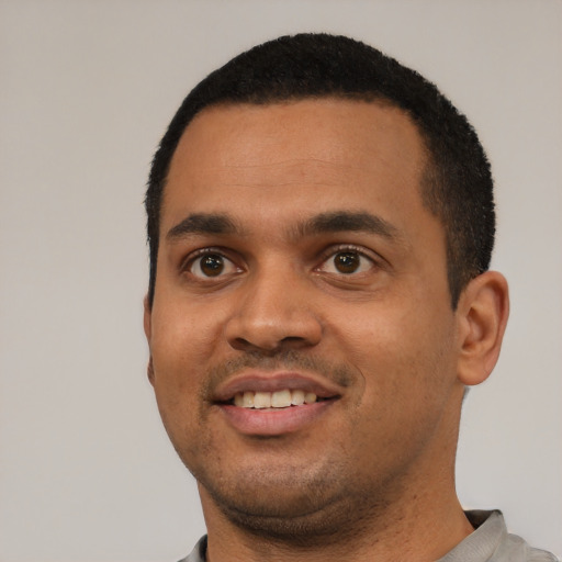 Joyful latino young-adult male with short  black hair and brown eyes