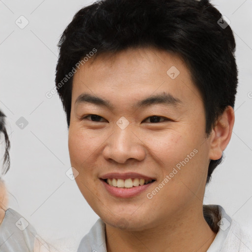 Joyful asian young-adult male with short  brown hair and brown eyes