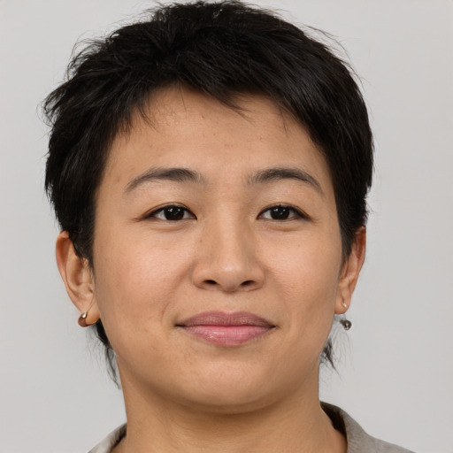 Joyful asian young-adult female with short  brown hair and brown eyes