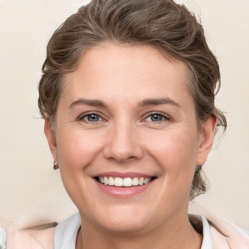 Joyful white young-adult female with medium  brown hair and grey eyes