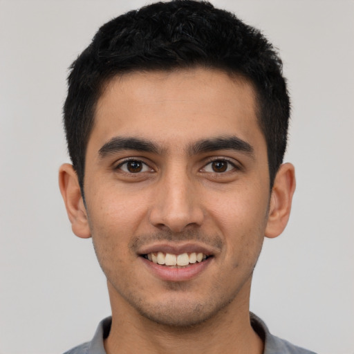 Joyful latino young-adult male with short  black hair and brown eyes
