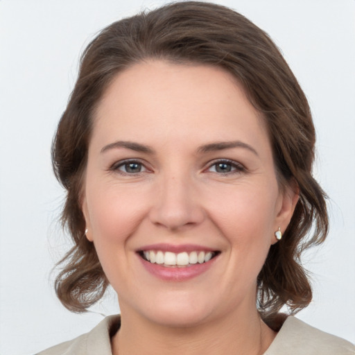 Joyful white young-adult female with medium  brown hair and grey eyes