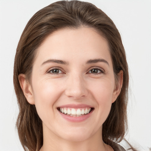 Joyful white young-adult female with medium  brown hair and grey eyes