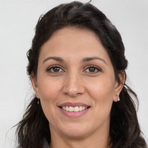 Joyful white adult female with long  brown hair and brown eyes