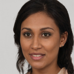 Joyful black young-adult female with long  brown hair and brown eyes