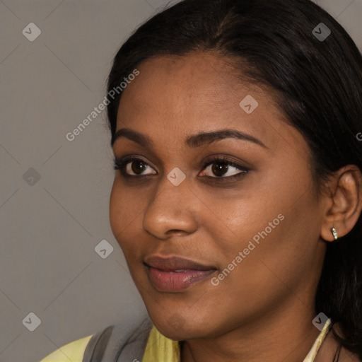 Joyful black young-adult female with long  brown hair and brown eyes