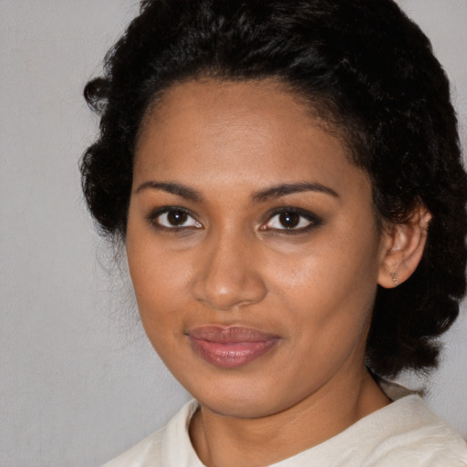Joyful black young-adult female with medium  black hair and brown eyes