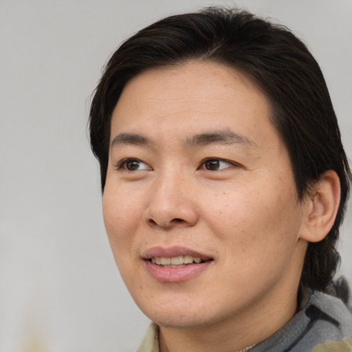 Joyful asian young-adult male with short  brown hair and brown eyes