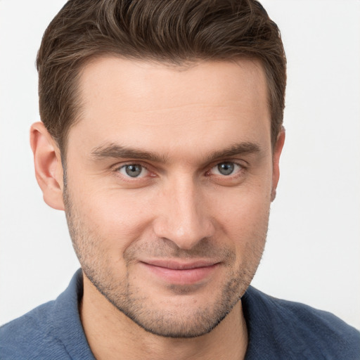 Joyful white young-adult male with short  brown hair and grey eyes