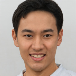 Joyful latino young-adult male with short  brown hair and brown eyes