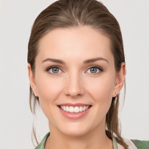 Joyful white young-adult female with medium  brown hair and grey eyes