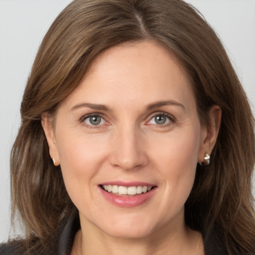 Joyful white young-adult female with long  brown hair and grey eyes