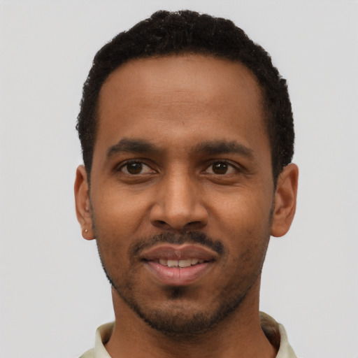 Joyful black young-adult male with short  black hair and brown eyes