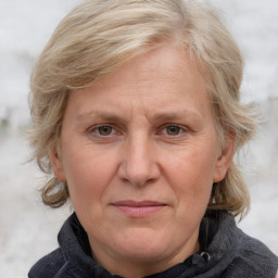 Joyful white adult female with medium  brown hair and blue eyes