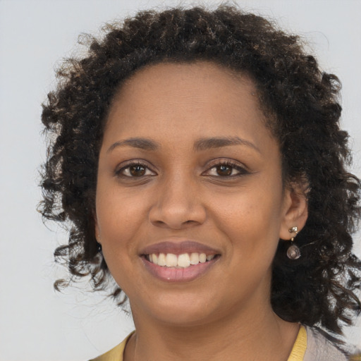 Joyful black young-adult female with long  brown hair and brown eyes