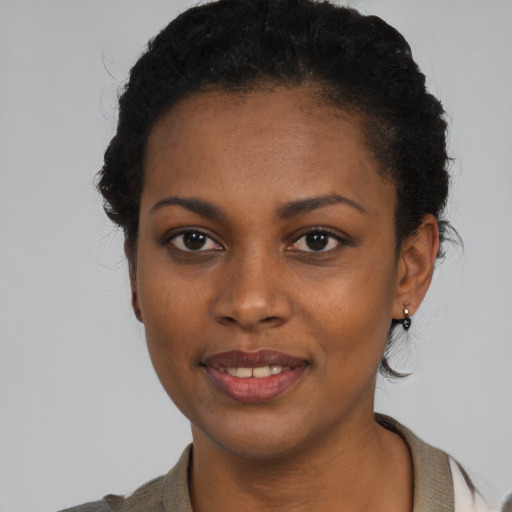 Joyful black young-adult female with short  black hair and brown eyes